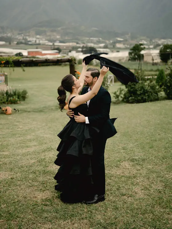 Chanelle y Sócrates bailan en el jardín; ella lleva un vestido negro