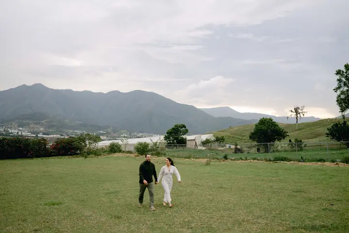 Caminan juntos, pequeños, en un valle con montañas al fondo